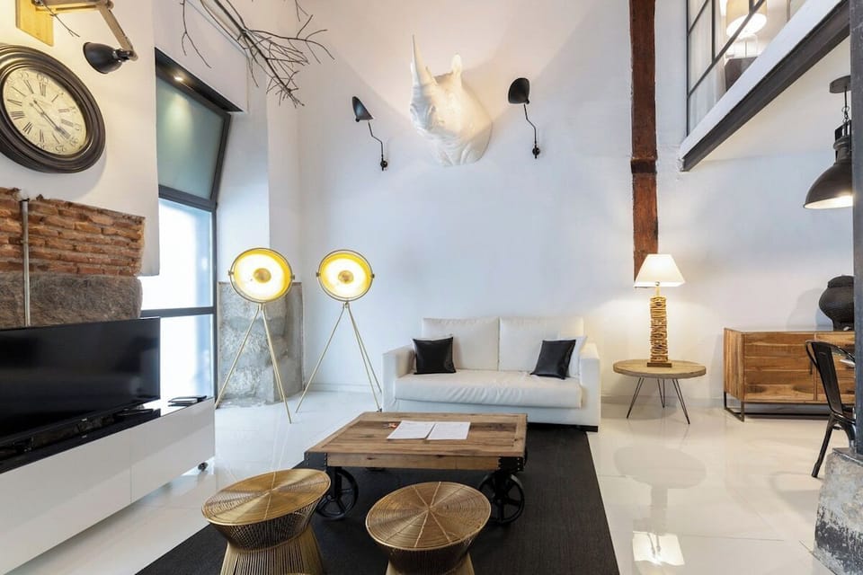 View of the living room, with a double sofa bed, television, armchairs and lamps.