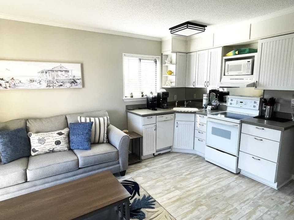 A fully equipped kitchen with crisp white cabinetry and modern appliances.