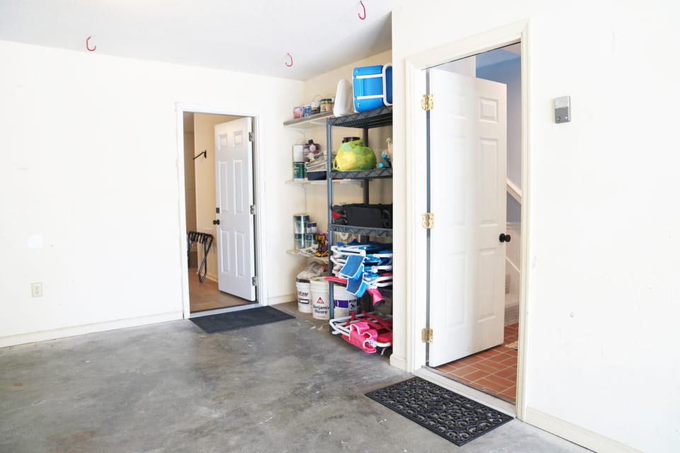 view of garage and access to the right to the main hallway and at the back to the ground floor suite.