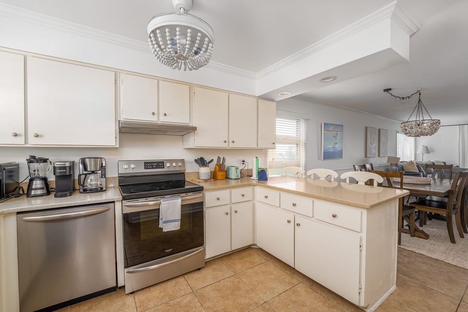 Fully stocked kitchen looks into dining and living areas.