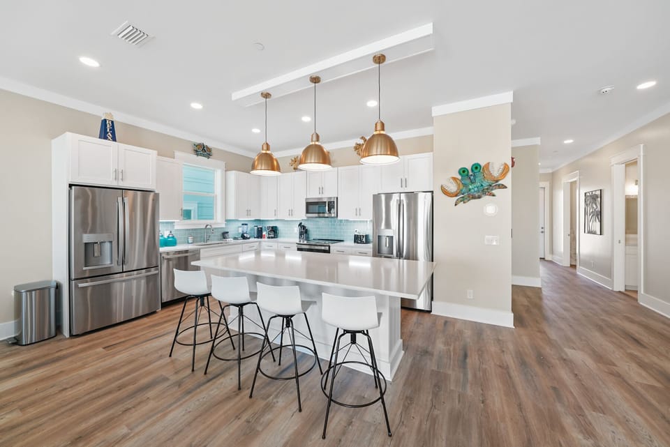 Your stunning open-concept kitchen awaits with sleek white cabinetry, gleaming quartz counters, and premium stainless appliances perfect for memorable meals together.