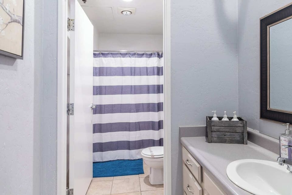 A Full Restroom with a hair dryer, shampoo, body wash, towels, toilet paper and conditioner