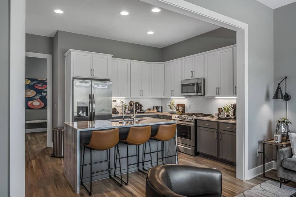 Open kitchen with island seating for three, ideal for cooking and chatting.