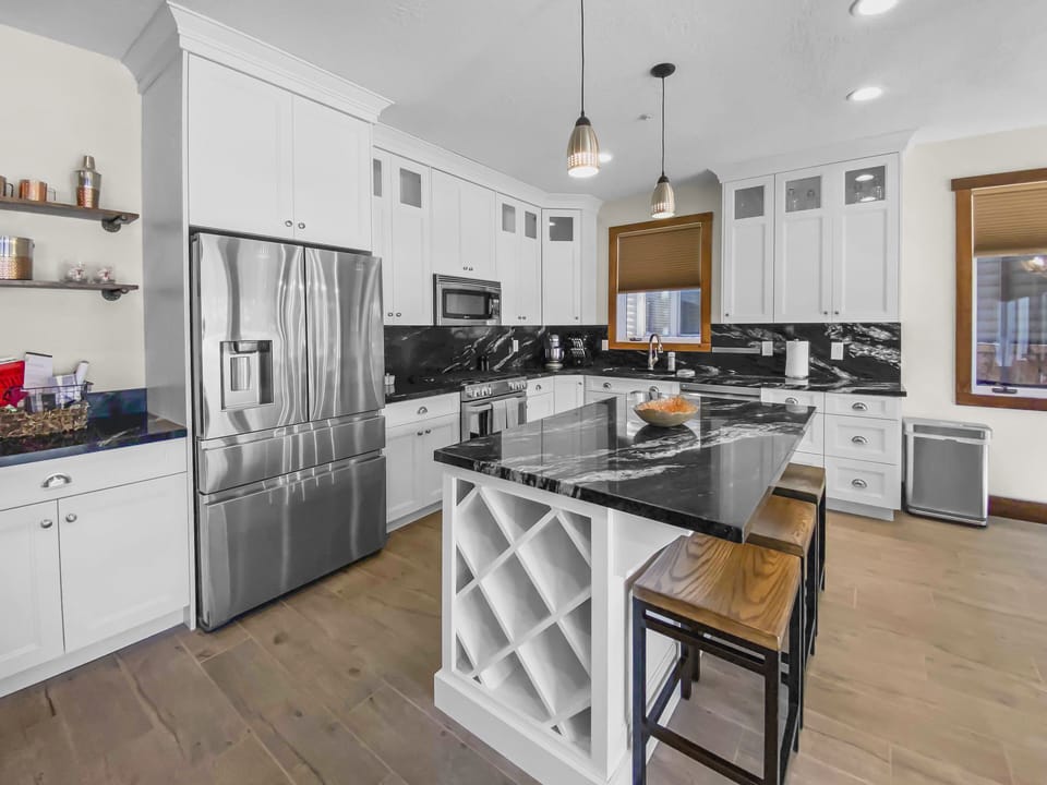 Enjoy this modern, fully equipped kitchen featuring a spacious island and stainless steel appliances. Perfect for preparing meals during your Park City getaway.