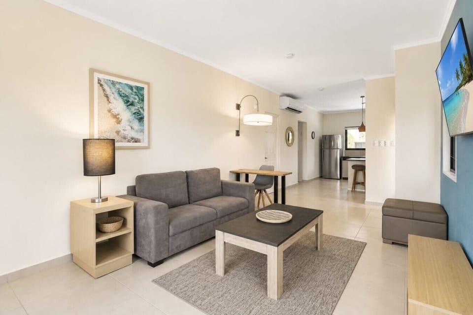 Cozy living room with comfortable seating, smart TV, natural light, and inviting atmosphere.