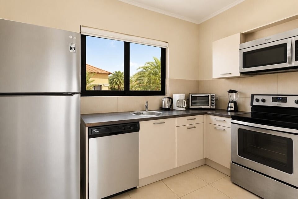 Fully equipped kitchen featuring modern appliances, cookware, essentials, and ample space for meal preparation.