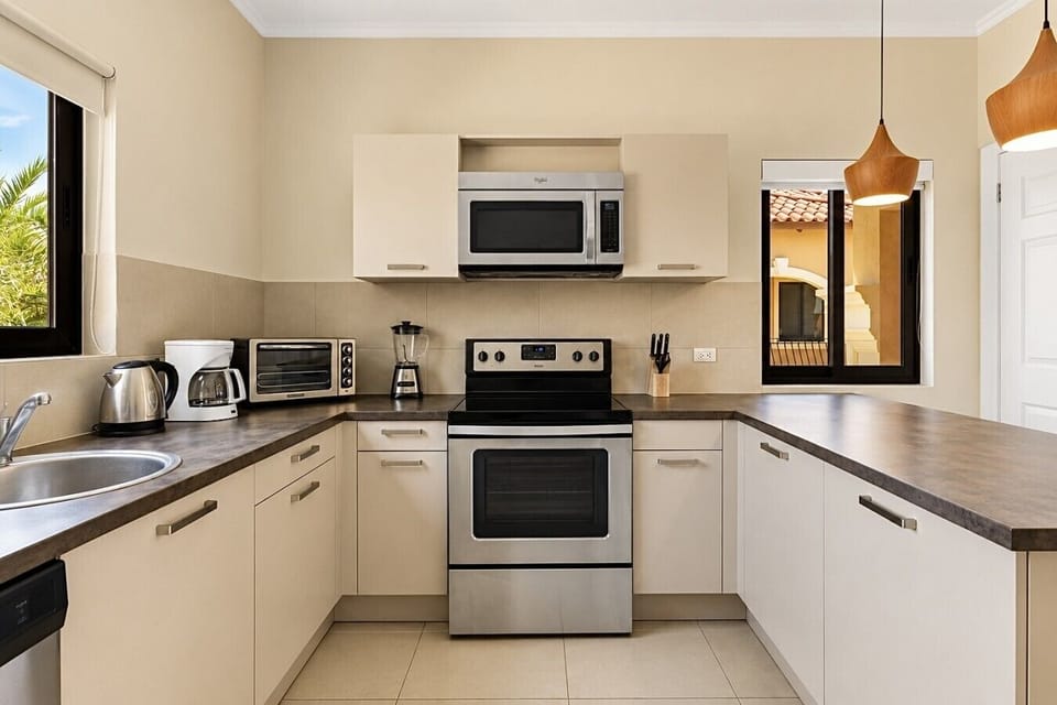 Fully equipped kitchen featuring modern appliances, cookware, essentials, and ample space for meal preparation.