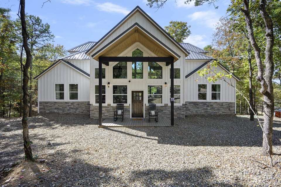 Charming Entrance: Stunning architecture with expansive windows and stone accents invites relaxation!