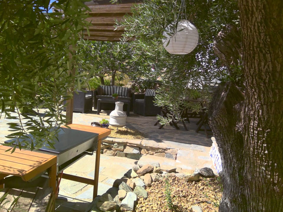 Shaded terrace with furniture and BBQ.