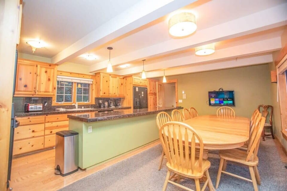 The large and well-equipped kitchen is complete with stainless steel appliances, granite countertops, and a large dining table providing all you need to prepare a delicious meal.