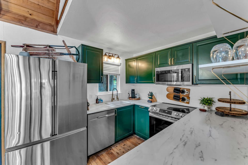 Kitchen: Stainless steel appliances, cooking utensils, kettle, coffee maker, tableware