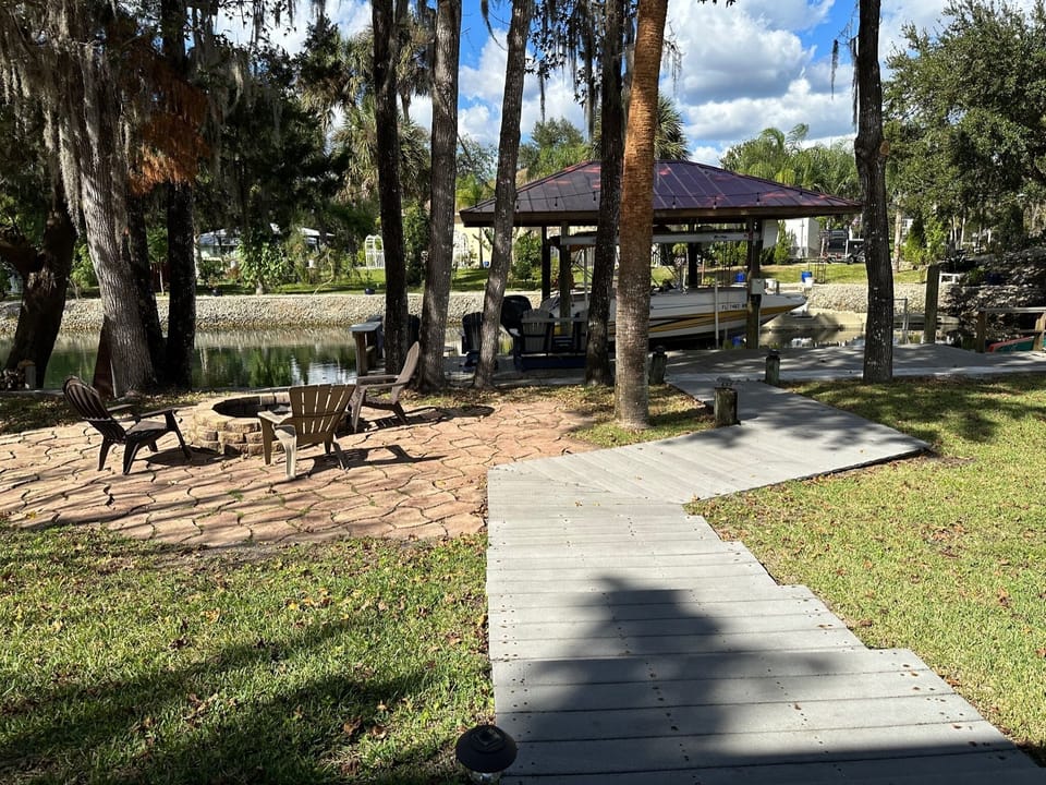 dock view from house of walkway to patio fire pit and c