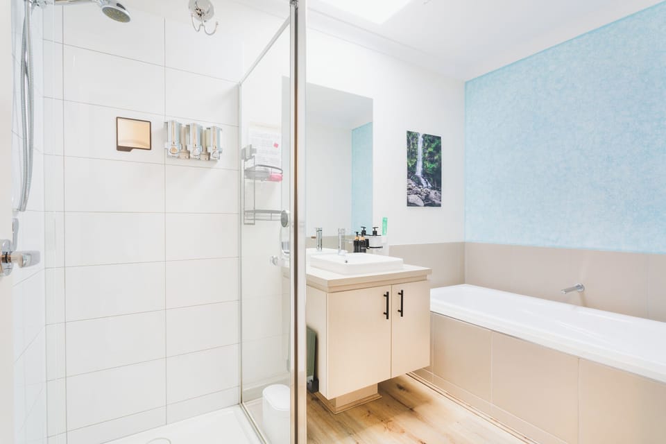 Main Bathroom with bath tub, shower, vanity, hair dryer and basic soap supplies