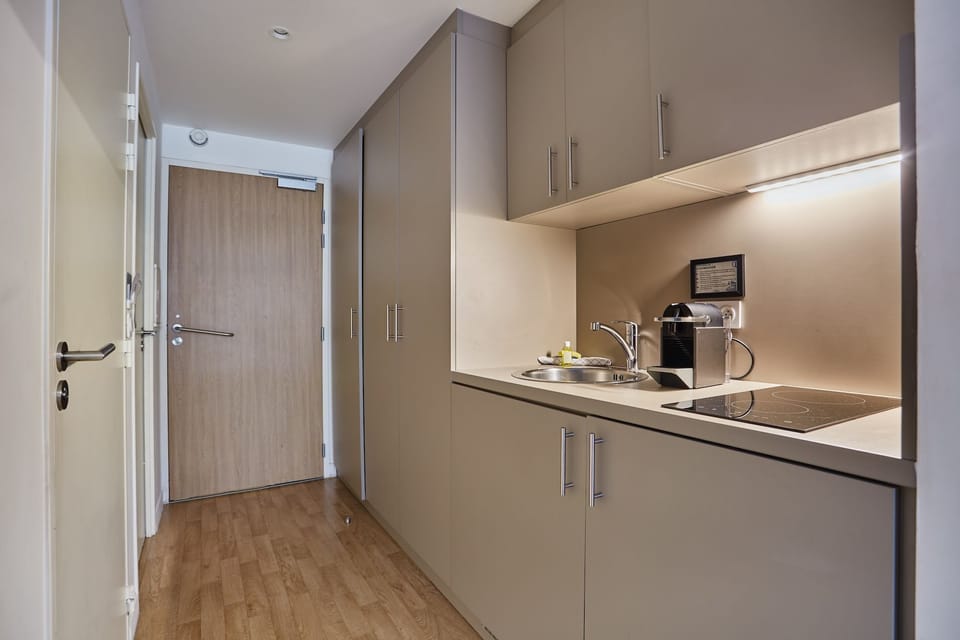 Compact kitchenette with modern appliances, ideal for simple meals during your stay.