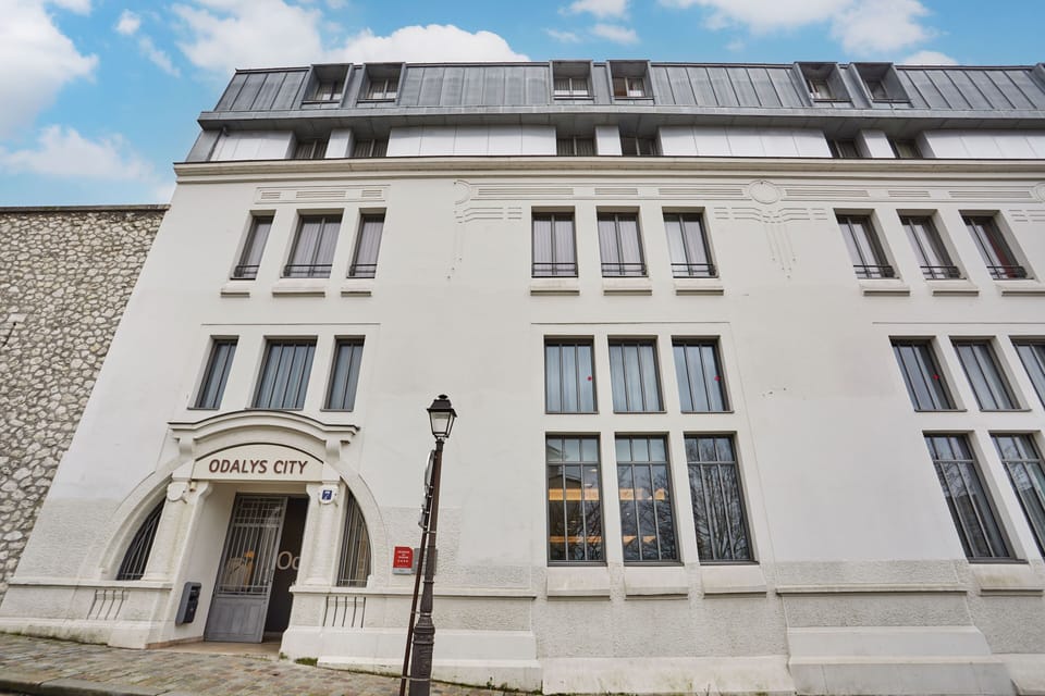 The charming stone facade of the residence blends seamlessly into Montmartre’s historic atmosphere.