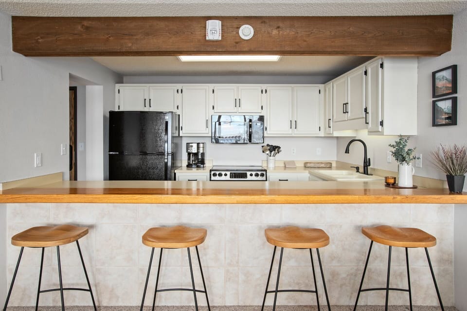 Breakfast Bar with 4 Wood Saddle Seat Stools with Iron Frames.
