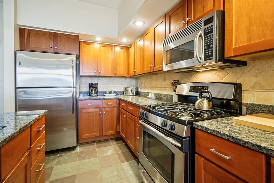Stainless-steel appliances, granite countertops, and warm wood cabinetry make this kitchen as functional as it is inviting. Everything you need is right at hand.