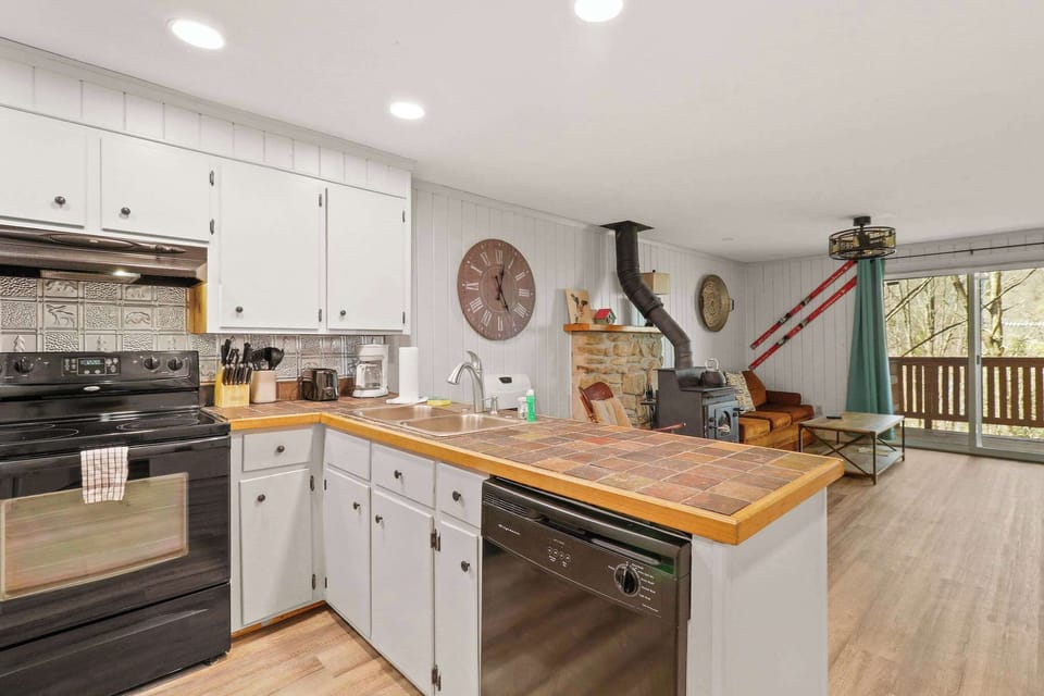 Kitchen elegance meets living room charm: A fully equipped kitchen and trendy bar seating area effortlessly merge with the inviting living space, promising countless unforgettable evenings.