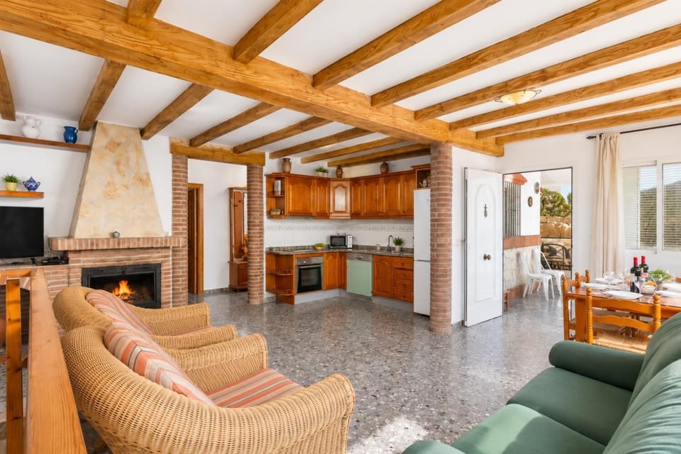Open-plan living room with sofa, dining area, kitchen, ornamental fireplace, A/C, WiFi internet, satellite TV, and sea views