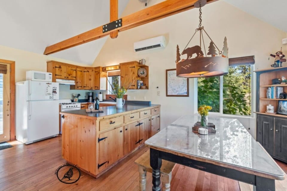 A bright and spacious kitchen with vaulted beams, plenty of counter space, and everything you need for easy meals. Large windows bring in forest views while the island and bar seating make it a welcoming place to prep, relax, and spend time together.