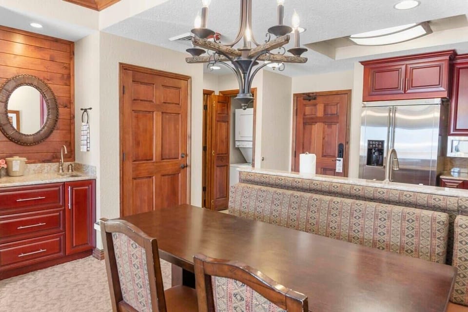 The dining area is comfortably placed on the other side of the kitchen with a table, cozy booth-style seating, and two chairs providing seating for four.