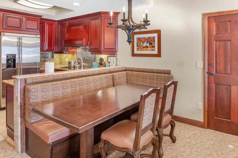 The dining area is comfortably placed on the other side of the kitchen with a table, cozy booth-style seating, and two chairs providing seating for four.