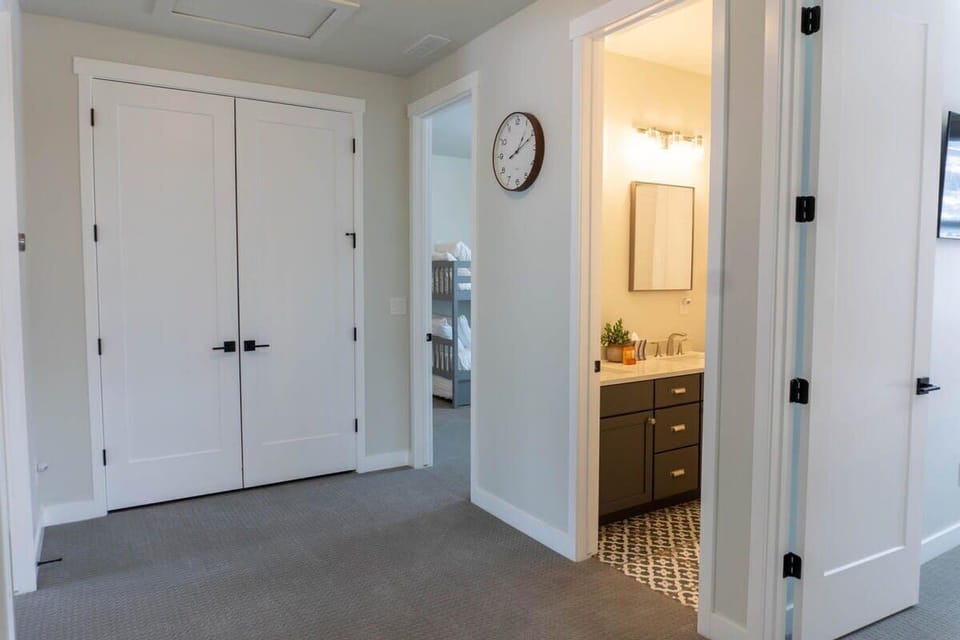 The view down the upstairs hallway shows the well-positioned full bathroom between the two guest bedrooms.