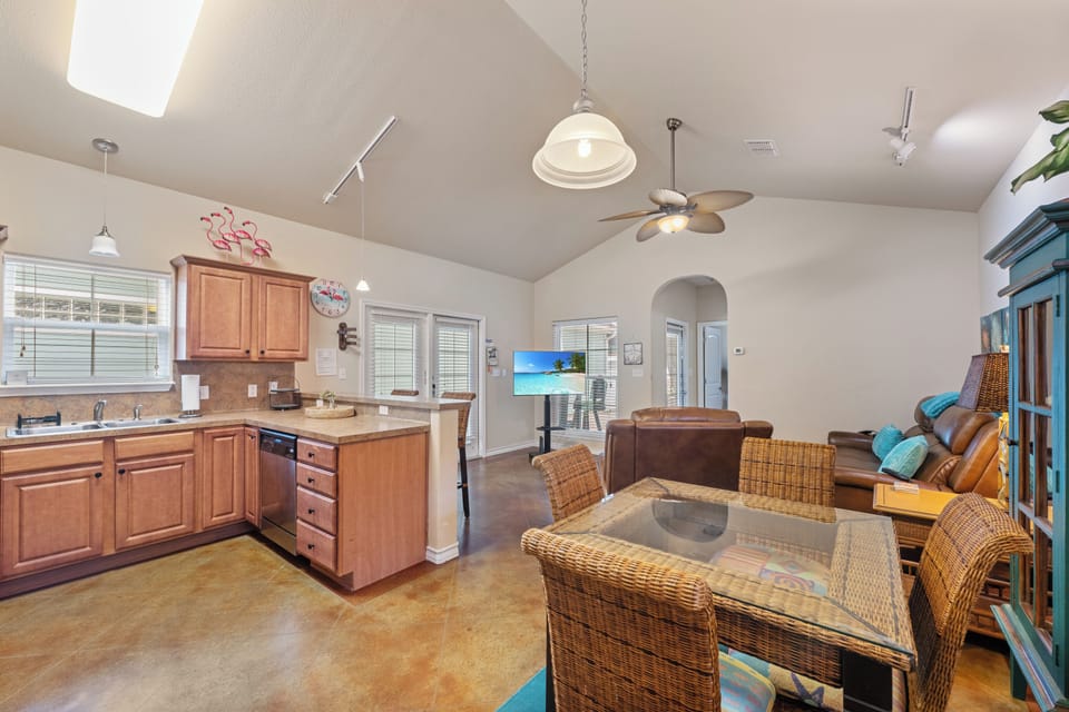 Your open-concept living space blends coastal charm with modern comfort, featuring a full kitchen and dining area for memorable meals.