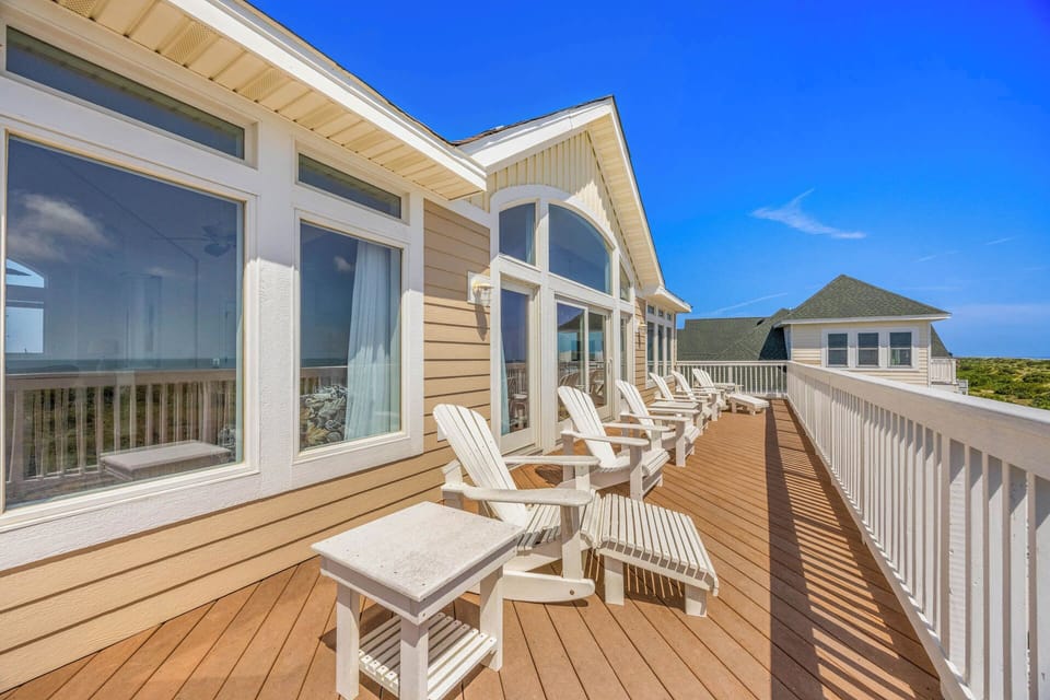 This spacious deck offers your perfect spot to relax in classic Adirondack chairs, soaking up sunshine and coastal breezes under brilliant blue skies.