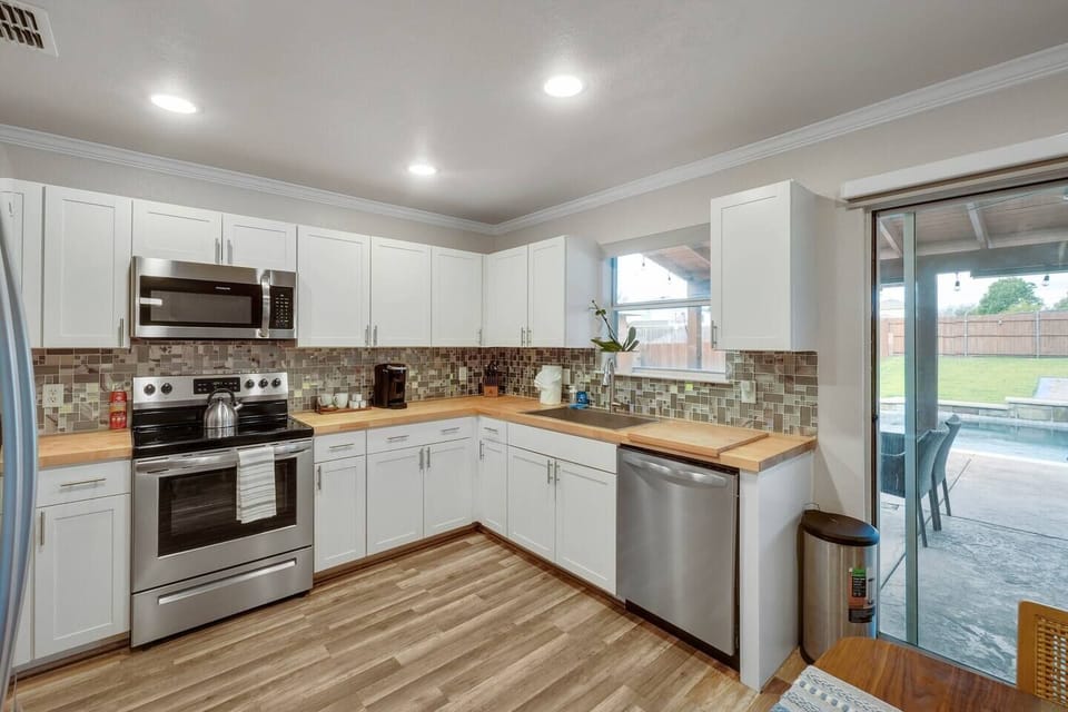The backyard is right outside the door of the beautiful open, concept kitchen