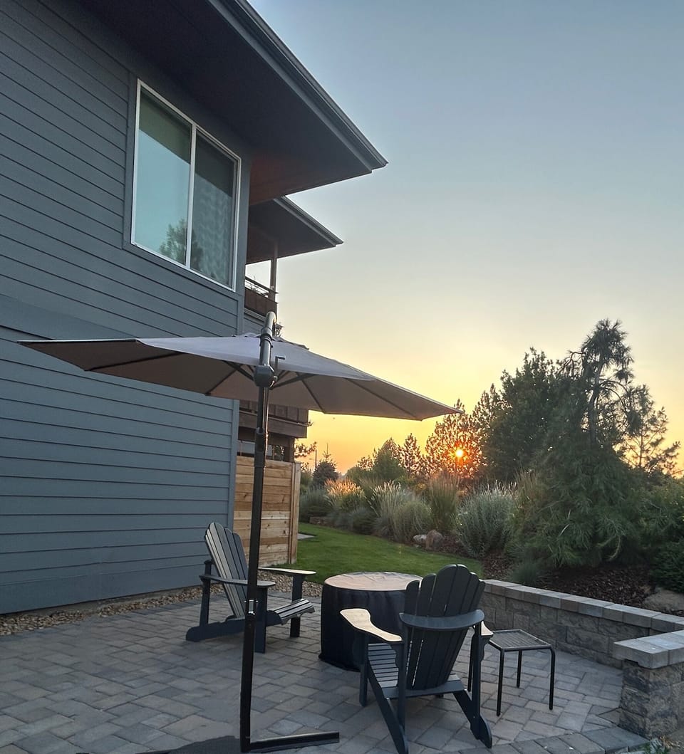 Firepit and patio with views of mountains, the river, and Old Mill Smokestacks.