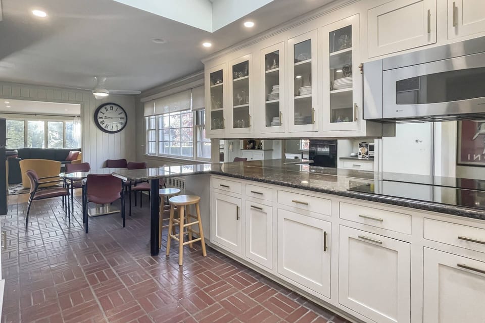 Culinary delights await in our modern kitchen featuring brick-look floors and open glass shelving.