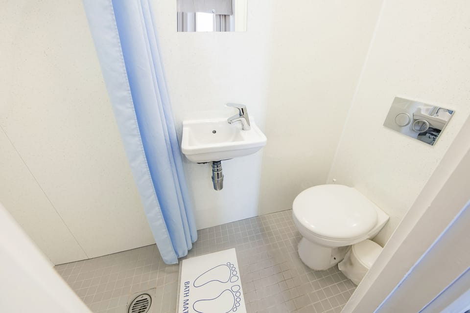 Budget quad ensuite (Basement Level) | Bathroom | Shower, hair dryer, towels