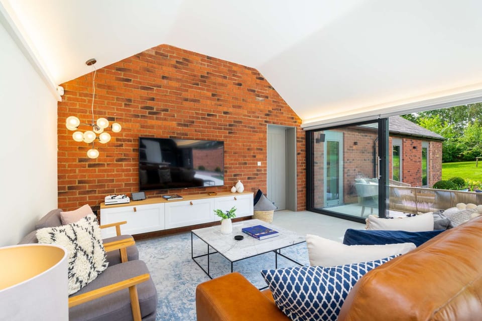The sitting room area, with its feature brick wall, is a warm and cosy area to relax and enjoy time together and reconnec