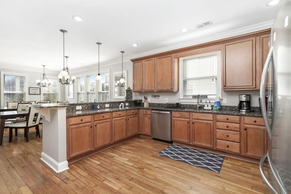 Your fully equipped kitchen features warm wood cabinets, granite counters, and stainless appliances perfect for creating memorable meals together.