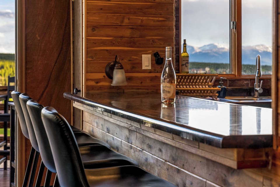 【Kitchen Bar】 4 bar stools at the black countertop — serves as the second dining spot