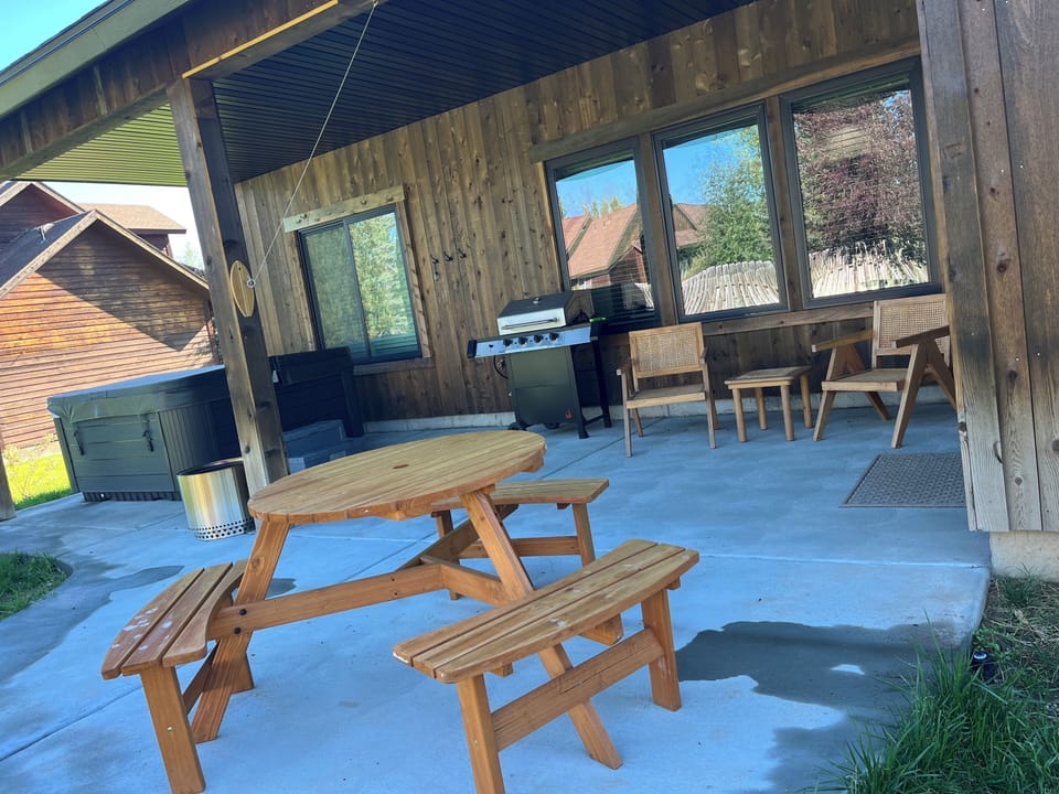 The back patio with hot tub, grill, ring toss and seating