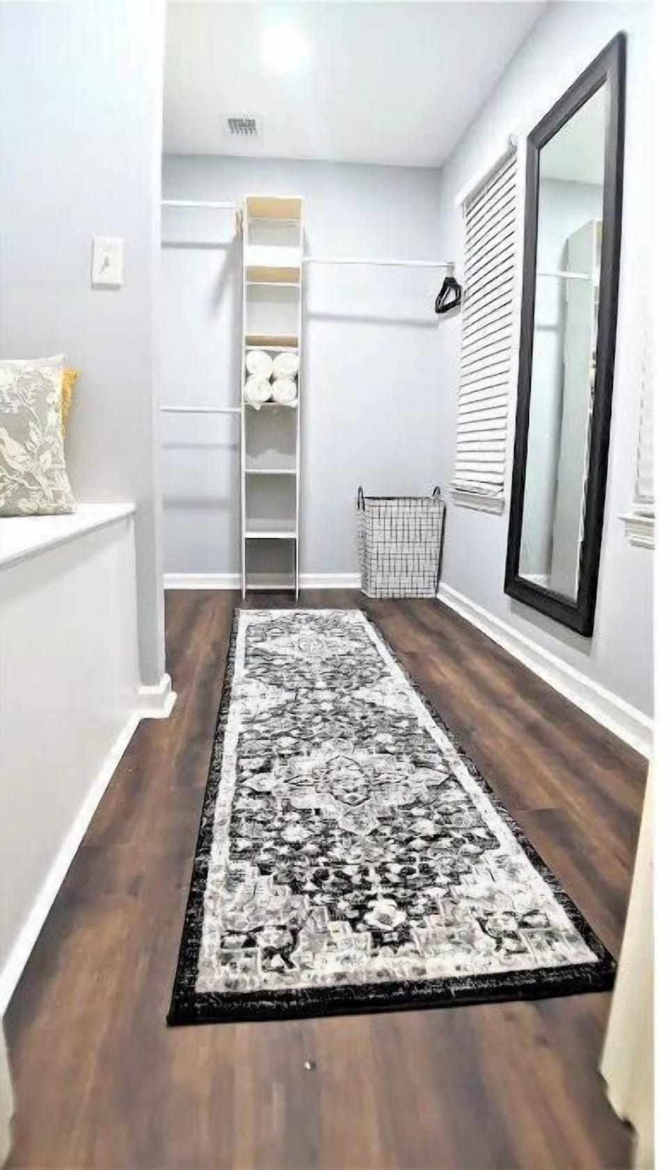 Walk-in closet master bedroom with extra towels, blankets and full length mirror