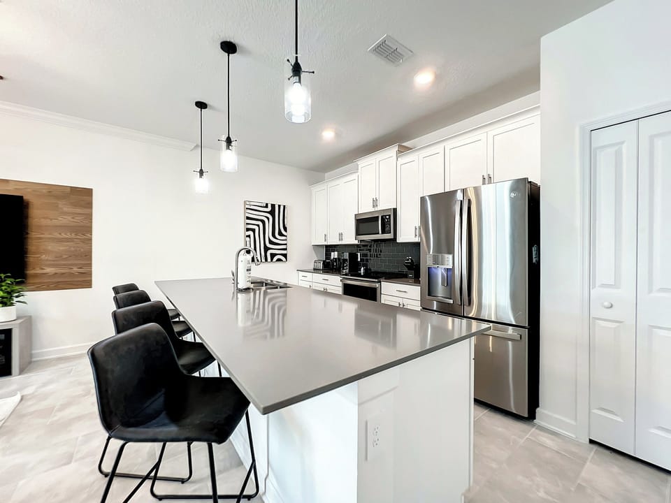 Modern kitchen with large breakfast bar and stainless steel appliances