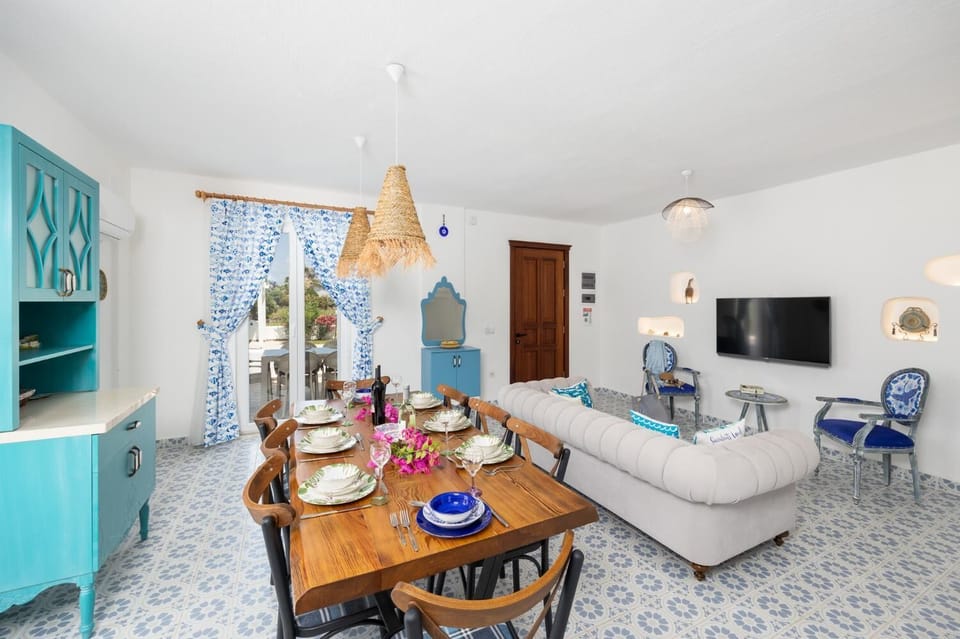 Open-plan living room with sofa, dining area, kitchen, A/C, WiFi internet, and satellite TV