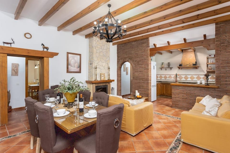 Open-plan living room with sofas, dining area, kitchen, ornamental fireplace, A/C, WiFi internet, satellite TV, and sea views
