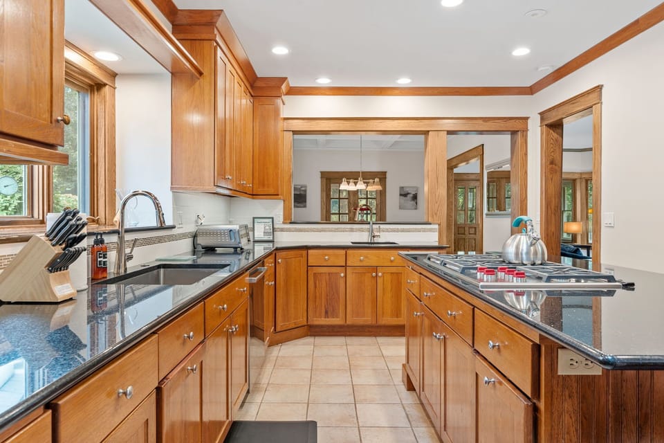Step into your fully equipped kitchen with granite counters, rich wood cabinets, and modern appliances—perfect for preparing memorable meals during your stay.