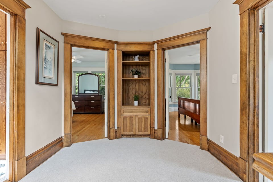 You'll love the elegant built-in corner cabinet with rich wood trim, creating a perfect reading nook with views into connecting rooms.