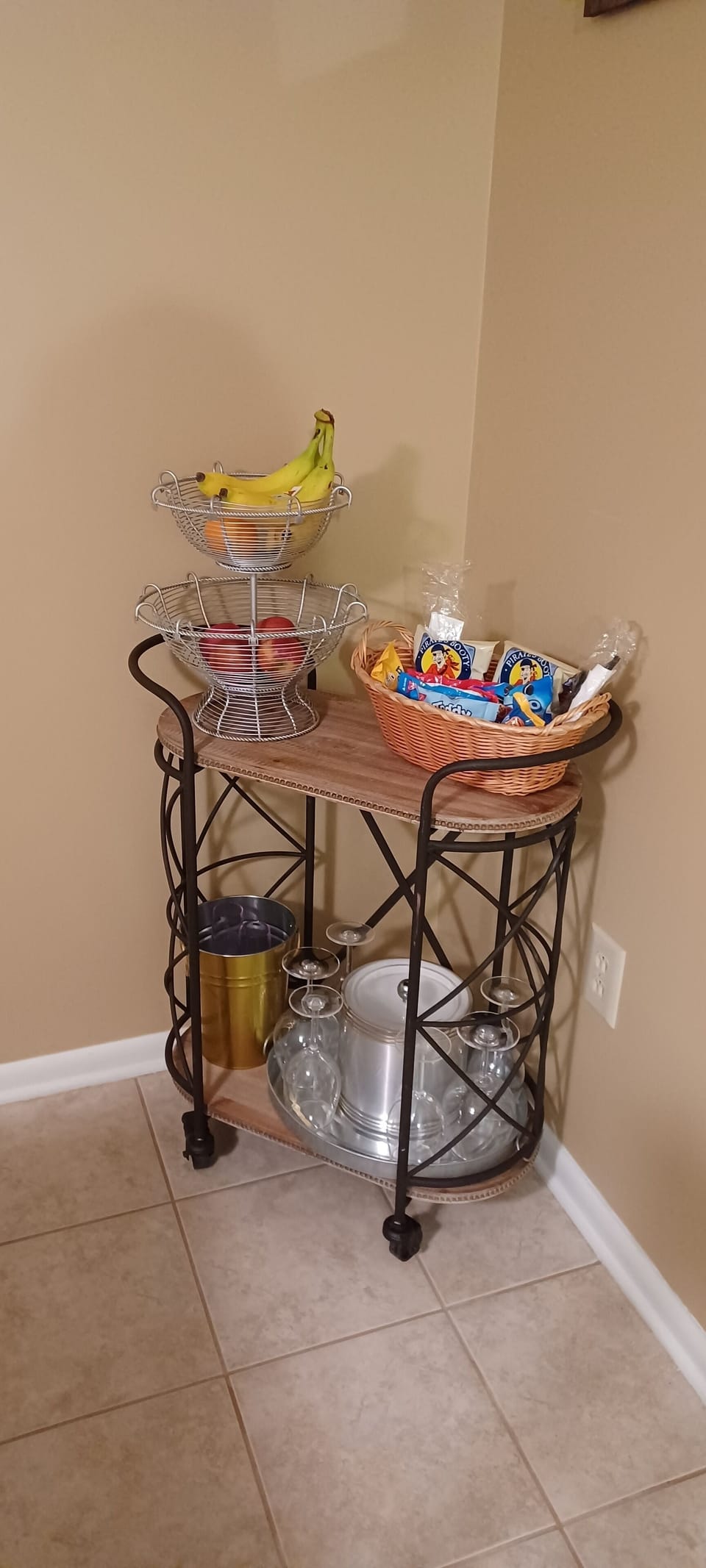 Hostess cart with fruit bowl, snacks, ice bucket, wine bucket, and serving tray.