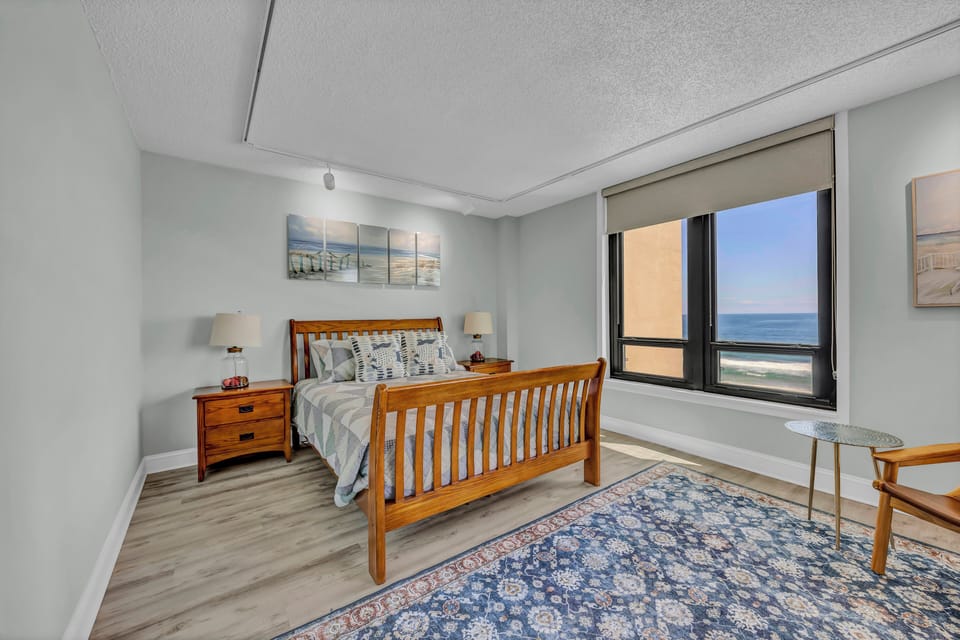 Wake to calming ocean breezes through your window, where soft coastal tones and warm wood furnishings create your peaceful retreat by the sea.
