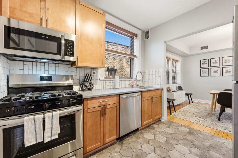 Fully stocked with cookware, dishes, and essentials for meals at home. Modern appliances include a dishwasher, microwave, coffee maker, kettle, and more.