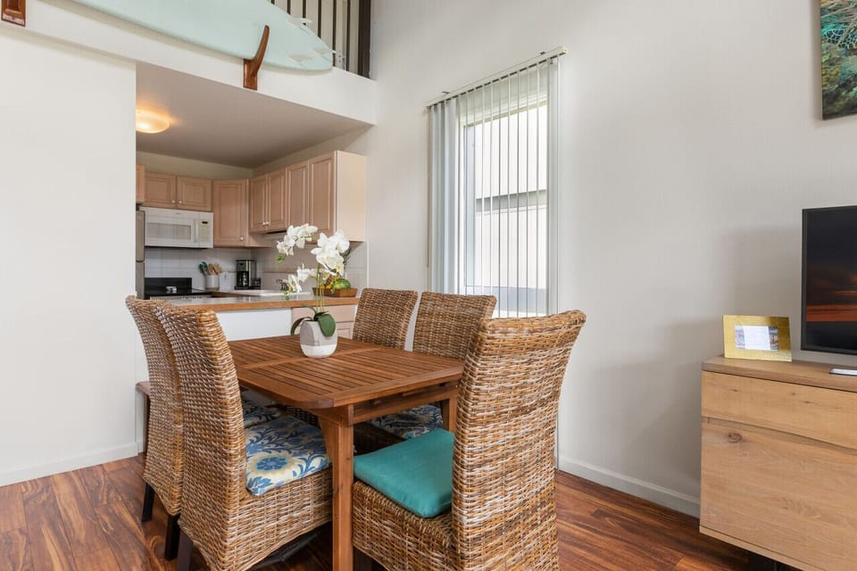 Bright dining nook w/ woven chairs & easy flow to the kitchen.