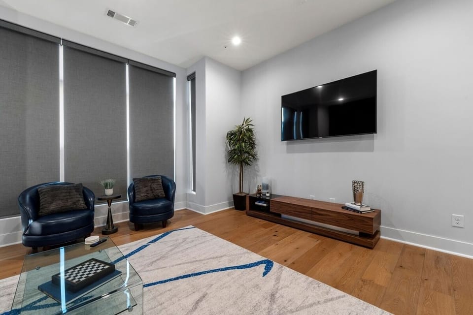 Living room, with large 75' TV, large windows, seats 8-10, lots of great lighting