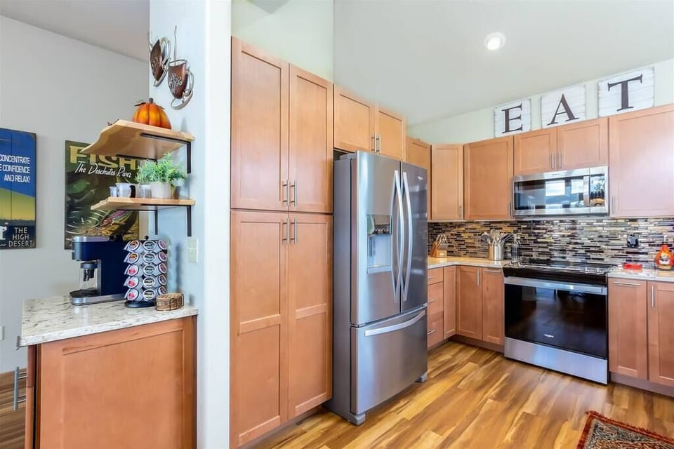 Kitchen features a glass top stove and stainless steel appliances