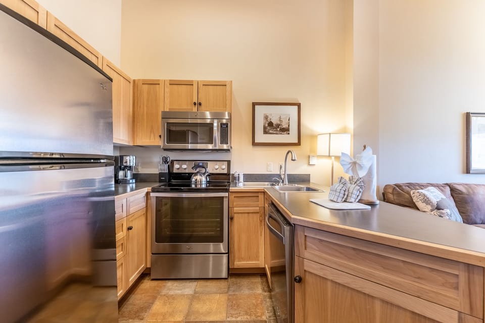 Your fully equipped kitchen awaits with stainless steel appliances, warm wood cabinetry, and everything you need to create memorable meals during your stay.